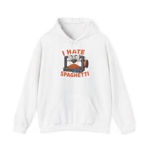 May include: A white hooded sweatshirt featuring a graphic of a 3D printer with an angry face printing a pile of orange spaghetti. The text above and below the graphic reads I HATE SPAGHETTI in bold orange capital letters. The hoodie has long sleeves.
