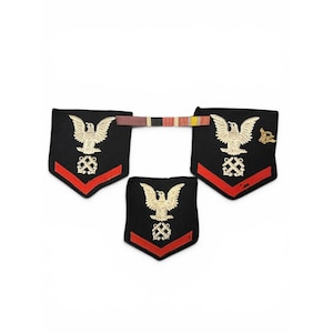 May include: Three black fabric military patches featuring an embroidered gold eagle above crossed anchors and a single red chevron. A thin, horizontal ribbon bar with red, black, and yellow stripes connects two of the patches at the top edge.