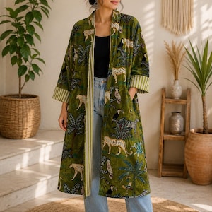 May include: A long, olive green open-front duster coat featuring a vibrant jungle print with leopards, toucans, and palm trees. The garment has three-quarter length sleeves with light green and white striped cuffs and a matching striped inner lining.