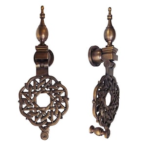 May include: Two views of a bronze-toned metal door knocker featuring a circular, intricate woven knot design. The hardware includes a vertical mounting plate, a hinged mechanism, and a decorative finial top with a pointed, bulbous shape.