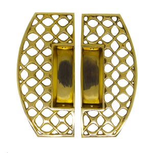May include: A pair of polished gold-tone metal door handles featuring a semi-circular shape with an intricate lattice cutout pattern. Each handle includes a recessed rectangular grip area with two visible screw holes for mounting purposes.