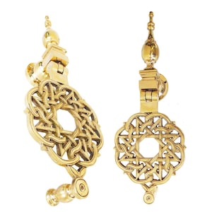 May include: Two polished brass door knockers featuring a circular, intricate, interlaced geometric knotwork design. Each knocker has a vertical mounting post topped with a decorative finial and a matching circular base plate for attachment to a door.