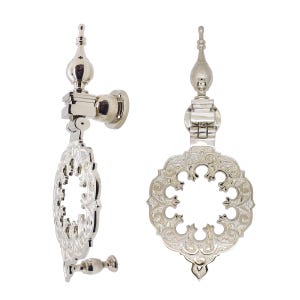May include: Two polished silver-tone metal door knockers shown from side and front angles. Each features a vertical mounting post topped with a finial and a circular, ornate, open-work ring with intricate embossed detailing and a bottom knob.