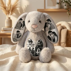 Op de afbeelding: Een grijze pluche konijnenknuffel met lange oren en een zachte, pluizige textuur. De binnenkant van de oren en een hartvormige patch op de borst zijn gepersonaliseerd met zwart-wit fotoprints van koppels in verschillende houdingen.