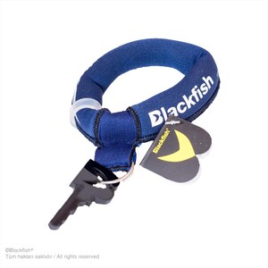 May include: A dark blue fabric wrist keychain featuring the white text Blackfish printed on the side. The circular band is attached to a black metal key and includes a heart-shaped black tag with a yellow crescent logo and the word Blackfish.