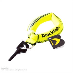 May include: A bright yellow floating keychain with a soft, padded loop and black stitching. The word Blackfish is printed in black on the loop. A black plastic key-shaped accessory is attached by a metal ring, along with a black branded paper tag.