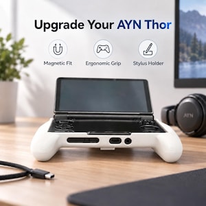 Puede incluir: Un accesorio de agarre ergonómico blanco para la consola de juegos portátil AYN Thor. El texto Upgrade Your AYN Thor aparece sobre tres iconos circulares etiquetados como Magnetic Fit, Ergonomic Grip y Stylus Holder. El dispositivo tiene una pantalla negra.