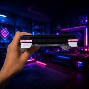 May include: A black handheld gaming console featuring a sleek, rectangular design with prominent shoulder buttons. The shoulder buttons are accented with textured pink and white grip covers, providing a distinct contrast against the black casing.