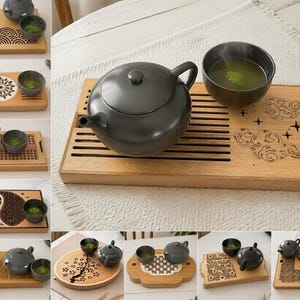May include: A dark gray ceramic teapot and a matching tea cup set on a rectangular bamboo tea tray. The tray features laser-engraved designs including clouds, stars, and geometric patterns. The set includes a lid and a spout on the teapot.