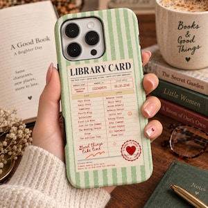 May include: A light green phone case with a vertical striped pattern featuring a vintage library card design. The card includes text such as LIBRARY CARD, member details, a list of book titles and authors, and a red heart stamp with the text Good things take time.