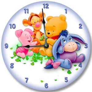 May include: A white clock face with a blue border featuring Winnie the Pooh, Piglet, Tigger, and Eeyore. The clock hands are set to 12:00.