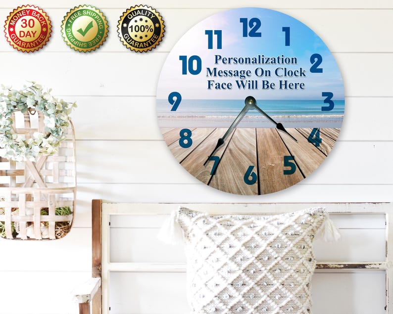 a wall clock with a beach scene as the background, and there are three badges on the wall above it.