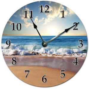 May include: Round wall clock featuring a beach scene with a blue ocean, sandy shore, and a bright sky. The clock face has black numerals and black clock hands. The clock hands point to 11:09. A decorative item for home decor.