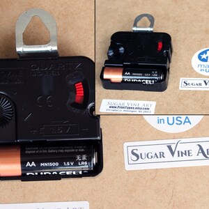 a black electronic device, possibly a clock, with a battery and a label indicating it is made in the USA.