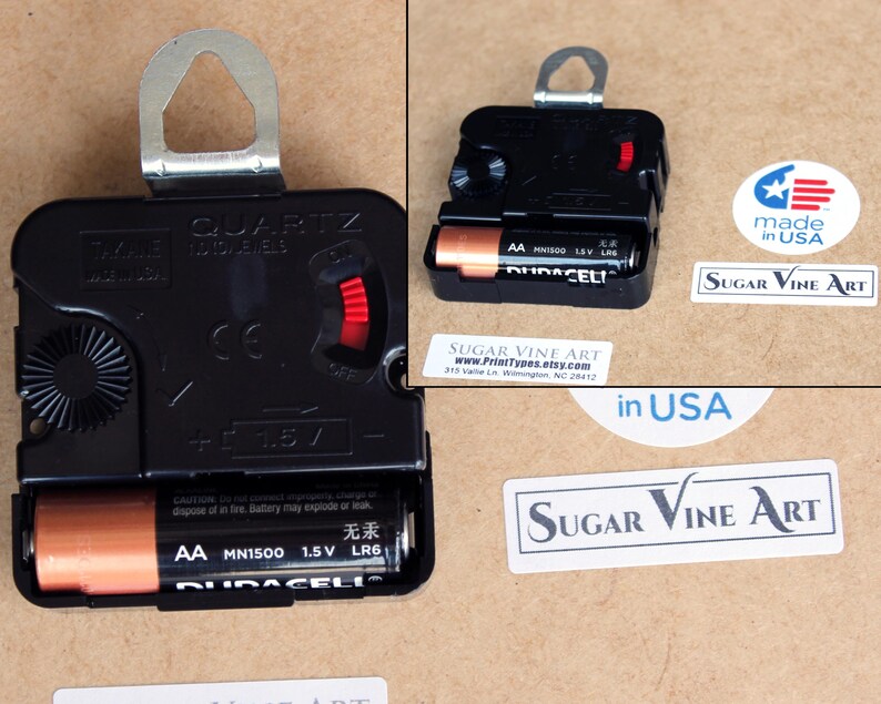 a black electronic device, possibly a clock, with a battery and a label indicating it is made in the USA.