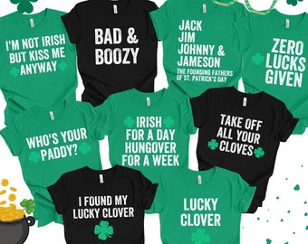 Könnte beinhalten: Ein Set aus zehn grünen und schwarzen T-Shirts mit verschiedenen Sprüchen zum Thema St. Patrick's Day. Die Shirts haben weißen Text und Kleeblatt-Designs. Die Sprüche lauten: "Ich bin nicht irisch, aber küss mich trotzdem", "Bad & Boozy", "Jack Jim Johnny & Jameson Die Gründerväter des St. Patrick's Day", "Zero Lucks Given", "Who's Your Paddy?", "Irisch für einen Tag, Kater für eine Woche", "Ich habe mein Glücksklee gefunden", "Zieh all deine Nelken aus", und "Lucky Clover".
