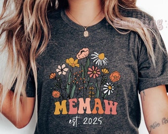 May include: Dark heather gray t-shirt with a floral design and the text "MEMAW est. 2025".