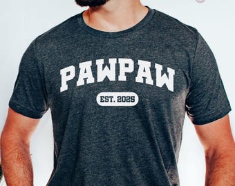 Puede incluir: Camiseta gris oscuro jaspeada con texto blanco que dice "PAWPAW EST. 2025".