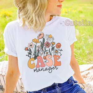 May include: White t-shirt with a floral design and the text "CASE manager" in colorful letters.