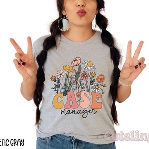May include: A gray t-shirt with a floral design and the text "CASE manager" in colorful letters.
