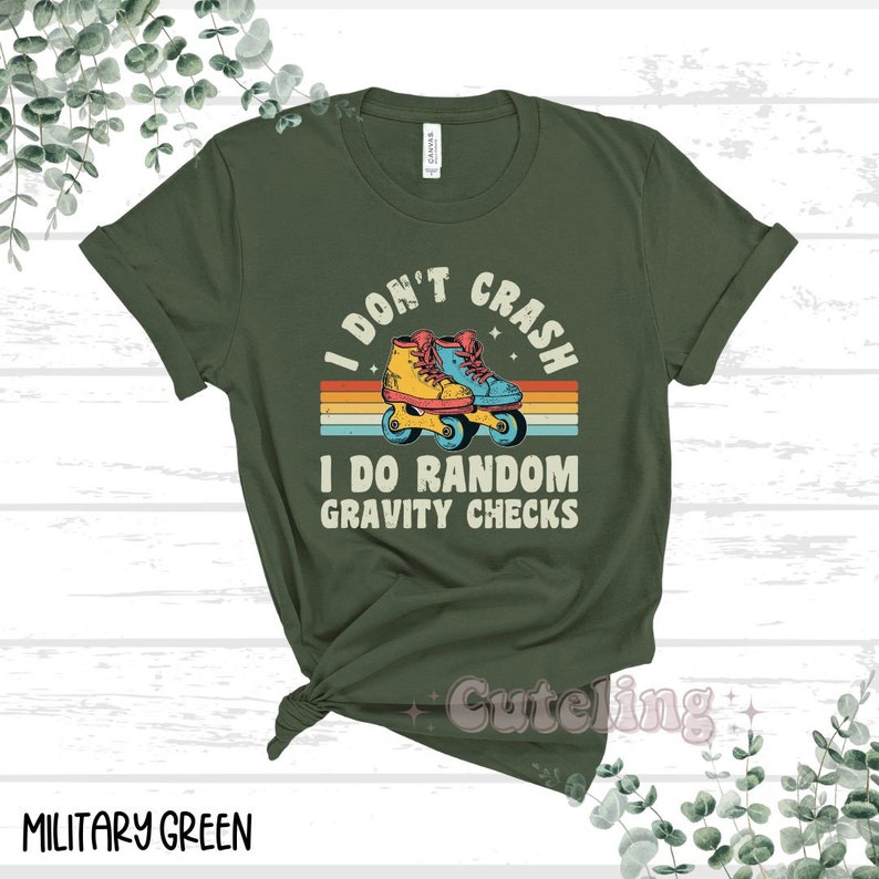 Pu&ograve; includere: Maglietta verde con un design retr&ograve; che presenta un paio di pattini a rotelle e il testo "I don't crash I do random gravity checks".