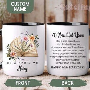 May include: White ceramic mug with a black handle and rim. The front features an open book illustration with floral accents and the text "CHAPTER 70 Nancy". The back reads "70 Beautiful Years" with a poem and "HAPPY 70th BIRTHDAY!"