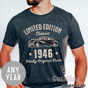 May include: Dark heather gray t-shirt with a vintage car graphic. The shirt features the text "LIMITED EDITION Classic 1946 Mostly Original Parts." A circular graphic on the bottom left says "ANY YEAR."