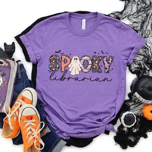 May include: Purple t-shirt with a graphic of a ghost and the text "Spooky Librarian".