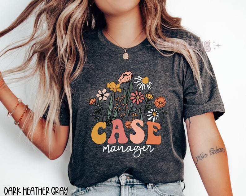 May include: Dark heather gray t-shirt with a floral design and the text "CASE manager" in a retro style.