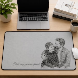 May include: A rectangular light gray desk mat featuring a black line art illustration of a parent and child embracing. The text "Dad, my forever friend" is printed in a cursive script in the lower left corner of the smooth, flat surface.