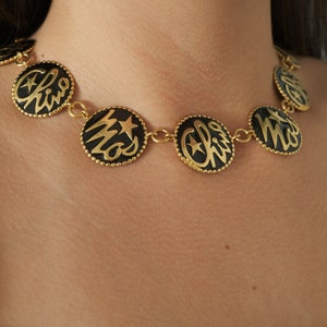 Collar vintage Moschino: Gargantilla con disco dorado y logotipo, esmalte negro