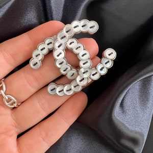 Chanel badge brooch deals