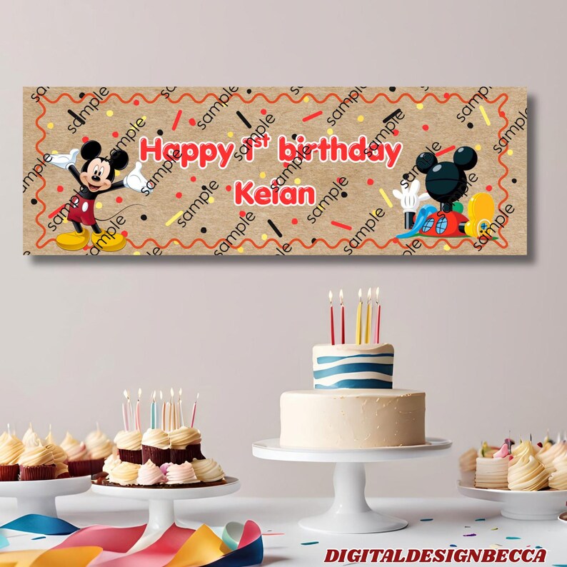 Pode incluir: Uma faixa retangular com fundo bege, borda ondulada vermelha, confetes coloridos e ilustra&ccedil;&otilde;es do Mickey Mouse. O texto diz Happy 1st birthday Keian. A faixa &eacute; exibida acima de um bolo de camadas e sobremesas menores.