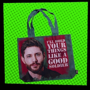 May include: Green tote bag featuring a portrait of a man and the text "I'll hold your things like a good soldier." The bag has green handles and a green background with white polka dots.
