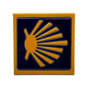 Peut inclure: Un carreau de céramique carré présentant un fond bleu foncé brillant avec un motif de coquille Saint-Jacques jaune stylisé au centre. Le carreau possède une épaisse bordure jaune encadrant le centre bleu foncé, créant un contraste marqué.