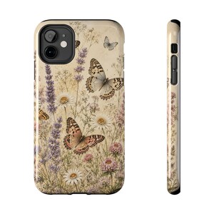 Peut inclure: Une coque de téléphone arborant une illustration botanique de style vintage sur fond crème. Le motif présente des brins de lavande violets, des marguerites blanches, des trèfles roses et plusieurs papillons aux motifs d'ailes complexes en brun.