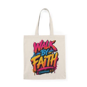 Könnte beinhalten: Eine beigefarbene Stofftasche mit einer lebendigen Graffiti-Grafik, die den Text "WALK BY FAITH" in fetten rosa, orangefarbenen und gelben Buchstaben zeigt, sowie "2 CORINTHIANS 5:7" in Blau darunter, akzentuiert durch farbige Farbtropfen.