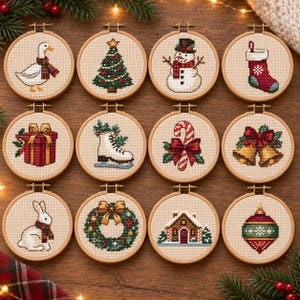 May include: Twelve circular wooden embroidery hoops containing cross-stitch designs featuring a goose, Christmas tree, snowman, stocking, gift, ice skate, candy cane, bells, rabbit, wreath, house, and ornament on beige fabric.