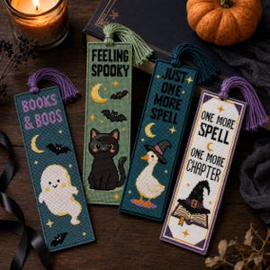 Könnte beinhalten: Vier rechteckige Kreuzstich-Lesezeichen mit Quasten. Das erste ist blaugrün mit einem Geist und 'BOOKS & BOOS'. Das zweite ist hellgrün mit einer schwarzen Katze und 'FEELING SPOOKY'. Das dritte ist dunkelblaugrün mit einer Ente im Hexenhut und 'JUST ONE MORE SPELL'. Das vierte ist weiß mit einem Buch und 'ONE MORE SPELL ONE MORE CHAPTER'.