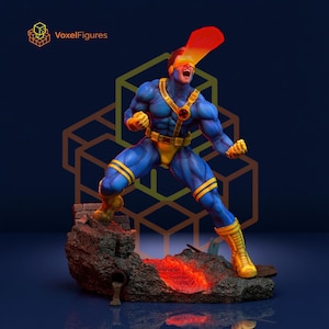 May include: A collectible figurine of a superhero character in a blue and yellow suit with a yellow visor, emitting a red and orange energy beam from the eyes. The figure stands on a textured, rocky base with a glowing orange lava-like fissure.