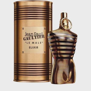 May include: A gold-toned cylindrical metal canister and a matching torso-shaped glass perfume bottle. The canister features horizontal ridges and a central plaque with the text Jean Paul GAULTIER LE MALE ELIXIR. The bottle has a ring at the neck.