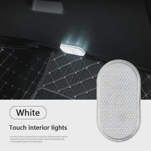 May include: An oval-shaped white touch interior light for vehicles with a textured surface. The light is shown illuminated in a dark car interior. Text on the image reads: White, Touch interior lights, and additional descriptive text.
