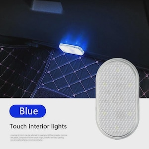 May include: An oval-shaped, white touch-activated interior light with a textured surface. The light emits a blue glow when illuminated. The product is labeled with the text Blue and Touch interior lights, featuring a grid-like pattern on the lens.