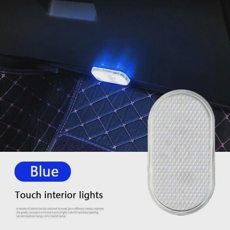 May include: An oval-shaped, white touch-activated interior light with a textured surface. The light emits a blue glow when illuminated. The product is labeled with the text Blue and Touch interior lights, featuring a grid-like pattern on the lens.