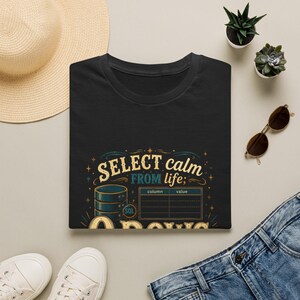 May include: A black t-shirt featuring a graphic print with the text "SELECT calm FROM life;" above a database icon, a SQL label, and a table with "column" and "value" headers. The design includes decorative flourishes and the word "0 ROWS" at the bottom.