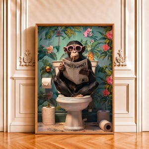 Könnte beinhalten: Ein gerahmter Kunstdruck, der einen Schimpansen mit rosa Brille zeigt, der eine Zigarre raucht und auf einer weißen Toilette sitzt, während er eine Zeitung namens Monkey Daily liest. Der Hintergrund zeigt eine tropische Tapete mit grünen Blättern und rosa Blüten.