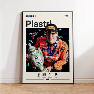 Könnte beinhalten: Ein gerahmtes Poster mit einem Foto eines lächelnden Rennfahrers in orangefarbenem Rennanzug und schwarzer Kappe, der einen grün-weißen Pokal hält. Der Text enthält 'Piastri', '2001' sowie Statistiken zu Grand-Prix-Siegen und Podiumsplätzen.