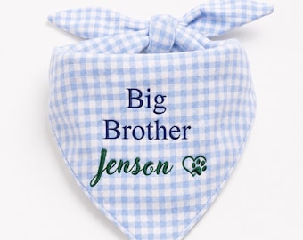 May include: A light blue and white gingham pet bandana featuring the embroidered text Big Brother in dark blue and the name Jenson in dark green script, accompanied by a small dark green embroidered paw print inside a heart outline.