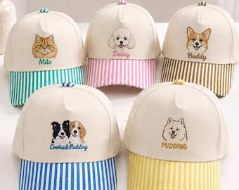 May include: Five off-white baseball caps with embroidered pet portraits and names. Each cap features a striped brim in green, pink, brown, blue, or yellow. The embroidery includes Milo, Daisy, Buddy, Cookie & Pudding, and Pudding with their names.