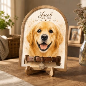 Może przedstawiać: Łukowata drewniana ramka z portretem golden retrievera i napisem Jacob 2012-2026. Brązowa skórzana obroża dla psa z okrągłą metalową zawieszką z wygrawerowanym imieniem Jacob jest przymocowana do przedniej części ramki.